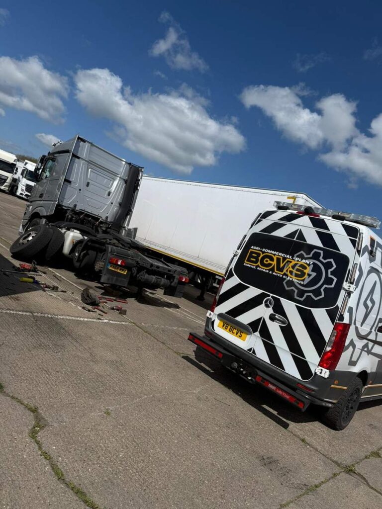 BCVS van beside an articulated curtainsider trailer on a yard under a cloudy sky