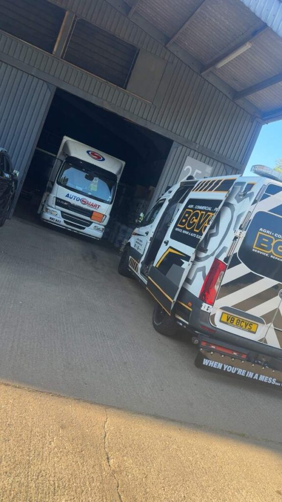 HGV tractor units lined up inside a depot shed with the BCVS van at the end of the row