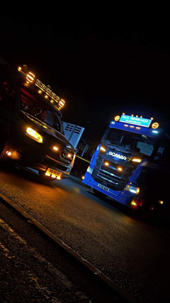Two lorries at night with newly fitted spot lamps and marker lights switched on