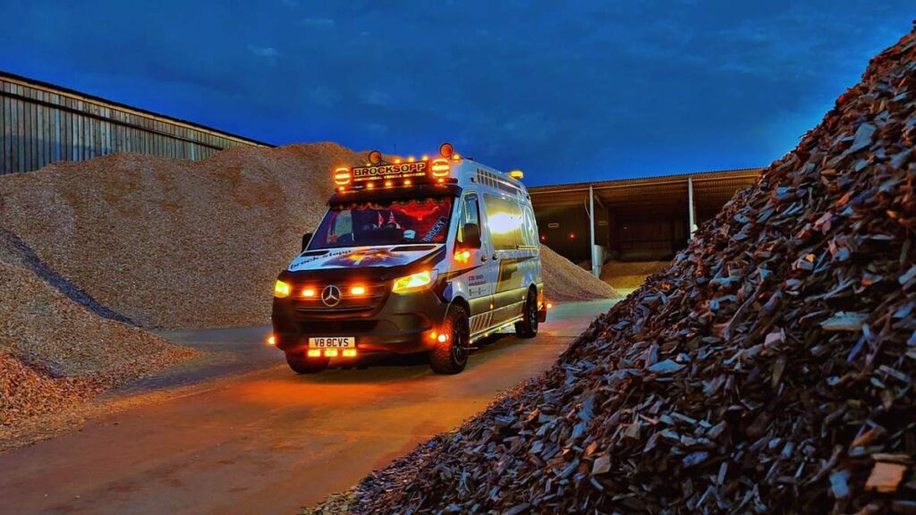 BCVS mobile service van with beacons lit, working between aggregate stockpiles at a quarry at dusk