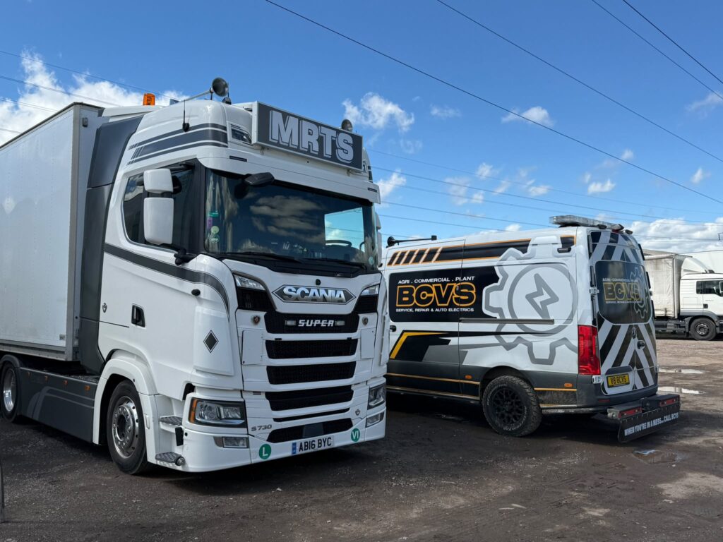 BCVS van parked beside a white Scania S730 Super in MRTS livery on a yard under a blue sky