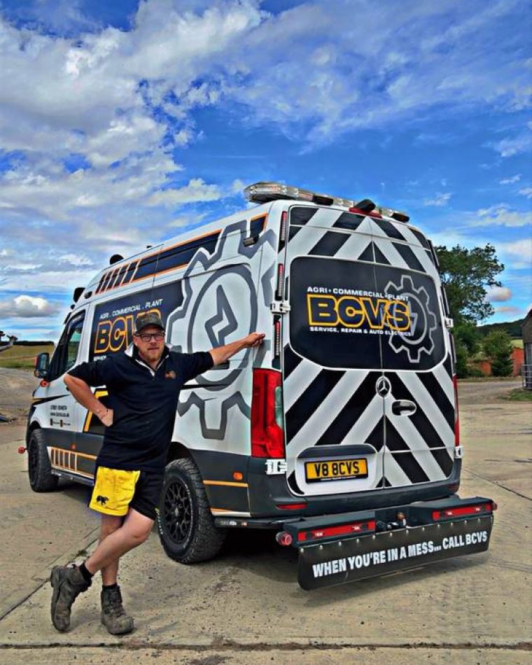 BCVS technician standing beside the liveried mobile service van on a bright day