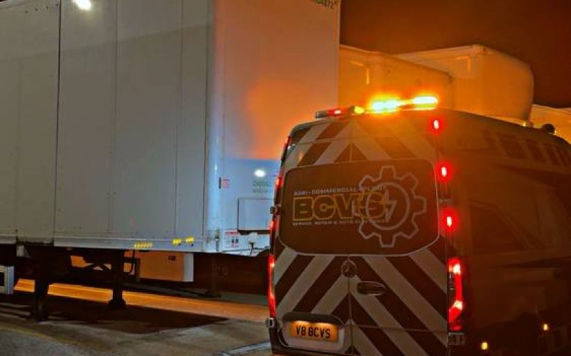 BCVS van working under amber beacons behind a stranded trailer during a night-time roadside electrical callout
